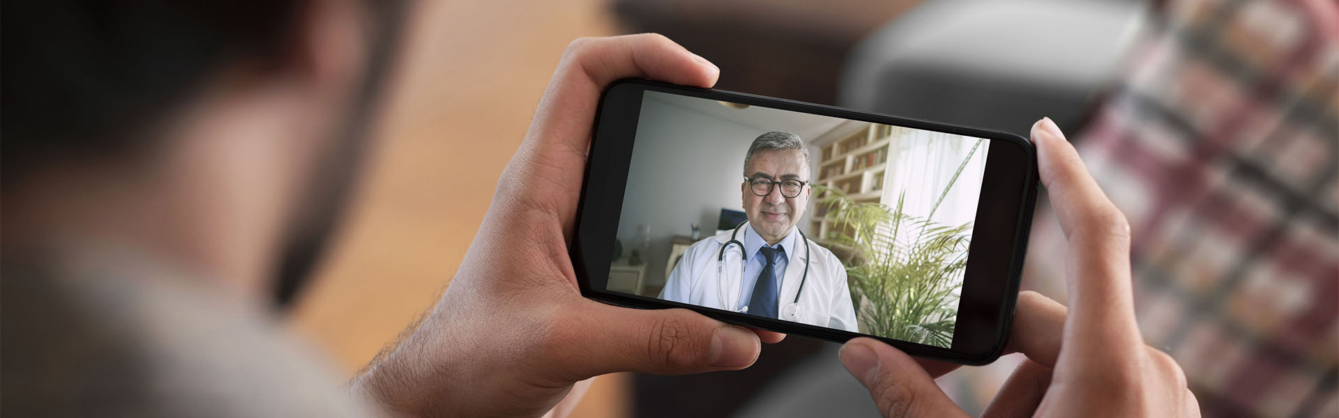 doctor on video screen of a phone being held by a man